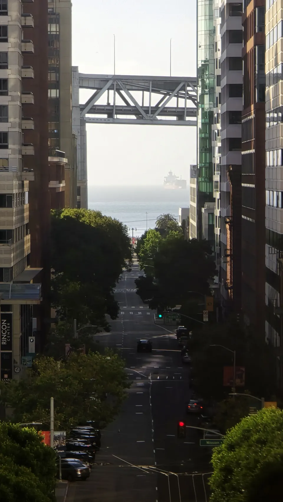 Looking down a tree-lined street toward the Bay Bridge