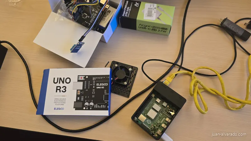 Raspberry Pi 4 in its case beside a cooling fan, an Arduino board and a temperature sensor
